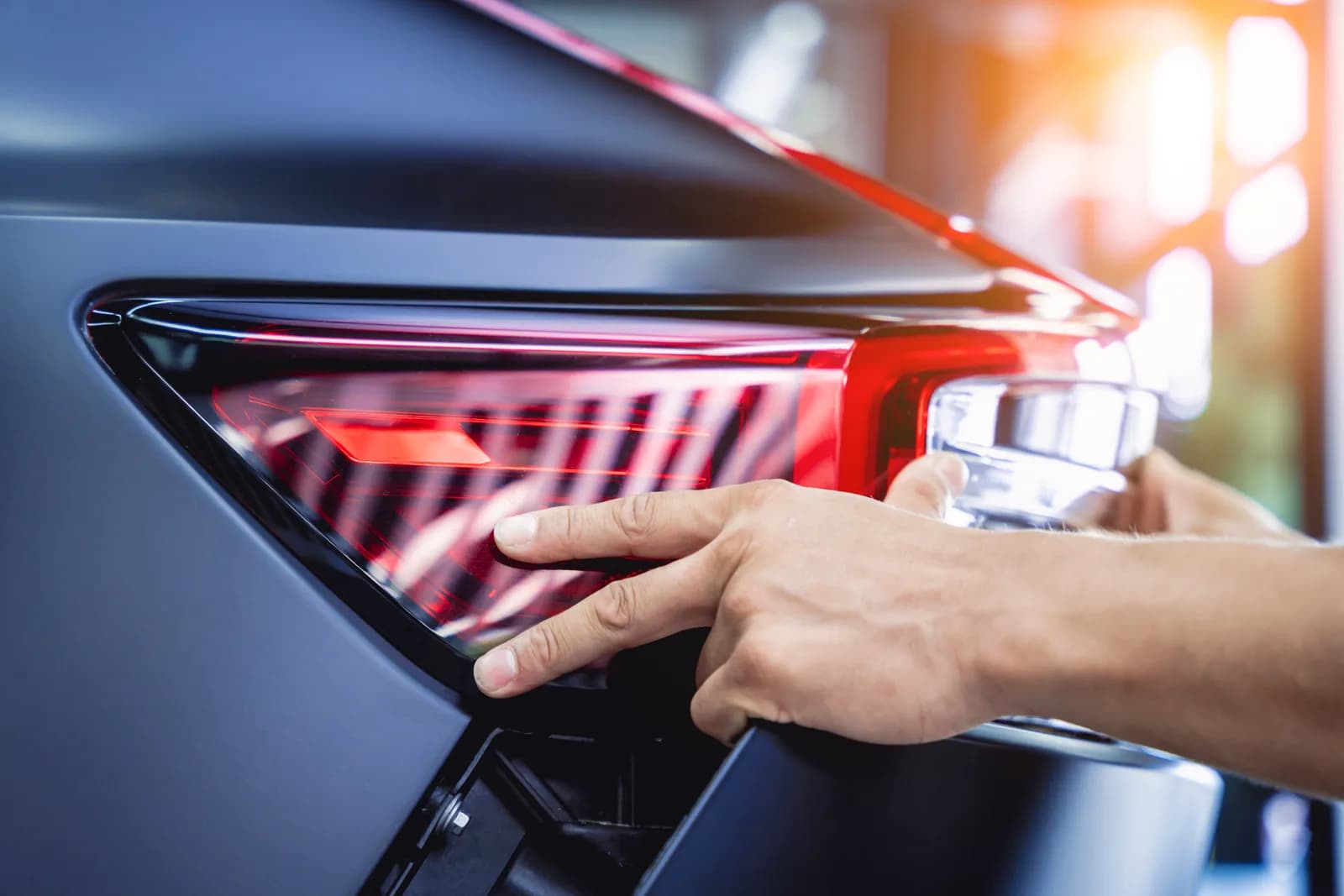 Professional auto body technician assembling vehicle components after paint at Gemini Auto Body San Jose