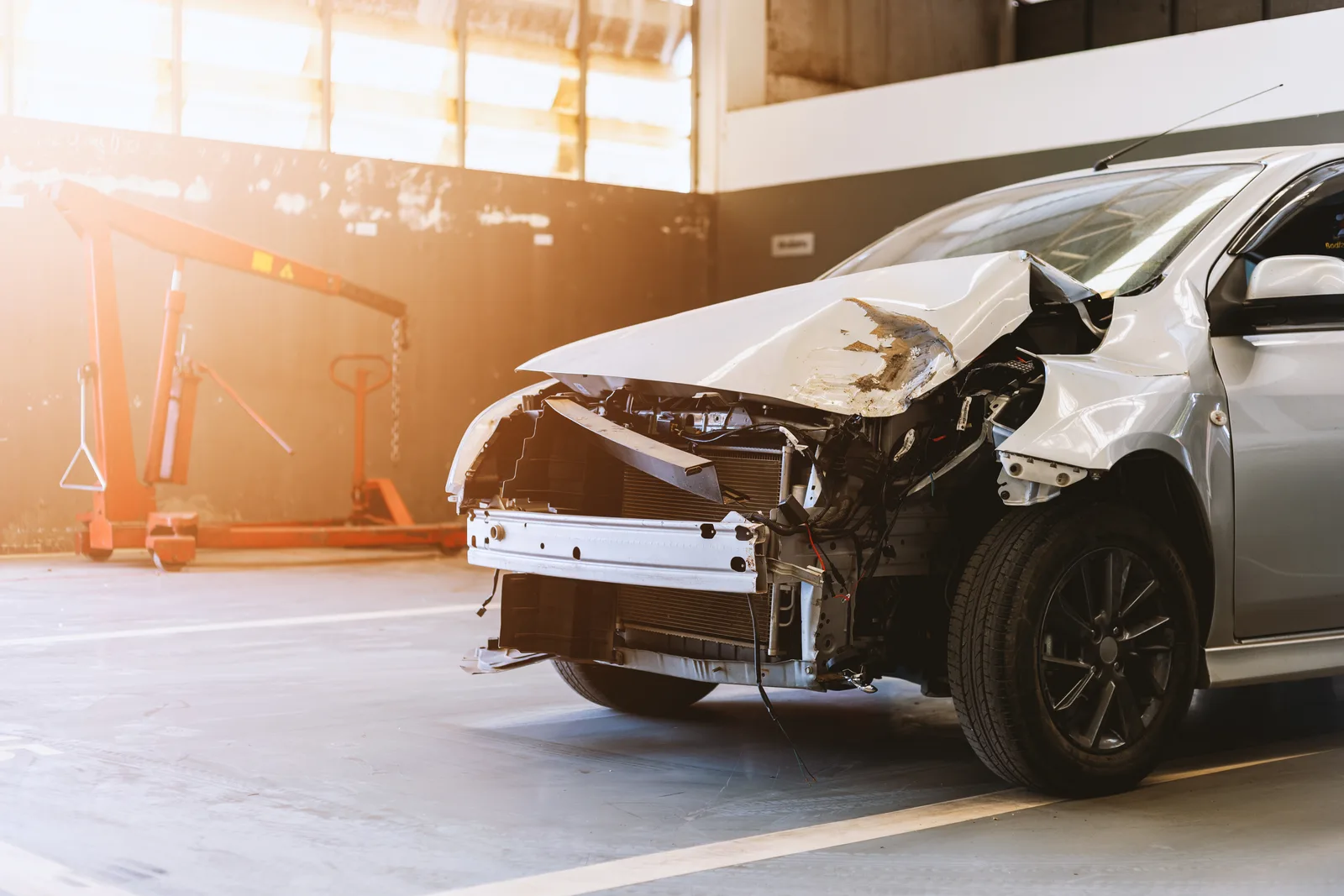 Severely damaged vehicle with front-end collision awaiting professional repair